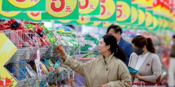 Mercado de consumo en China con productos en estantes y compradores, reflejo de la baja inflación en julio 2026