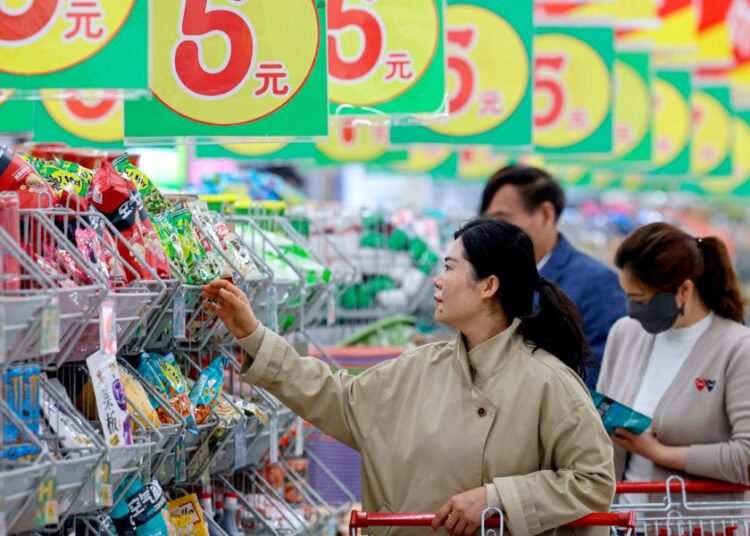Mercado de consumo en China con productos en estantes y compradores, reflejo de la baja inflación en julio 2026