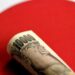 Billetes de yen japonés y dólares estadounidenses sobre una pantalla con cotizaciones cambiarias