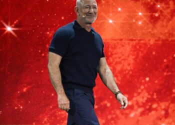 Jeff Bezos sonriente en evento público, mientras el Liverpool FC anuncia su entrada como inversor minoritario en el club inglés
