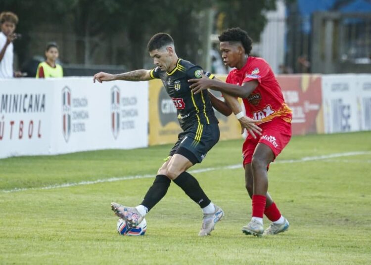 Jugadores de Moca FC y Atlético Vega Real disputando el balón en el estadio Moca 85 durante el partido inaugural de la LDF 2026-2027