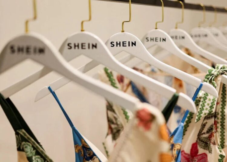 Tienda física de Shein con ropa exhibida y compradores en un centro comercial