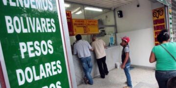 Billetes de pesos colombianos y dólares sobre una mesa durante semana de alta volatilidad cambiaria