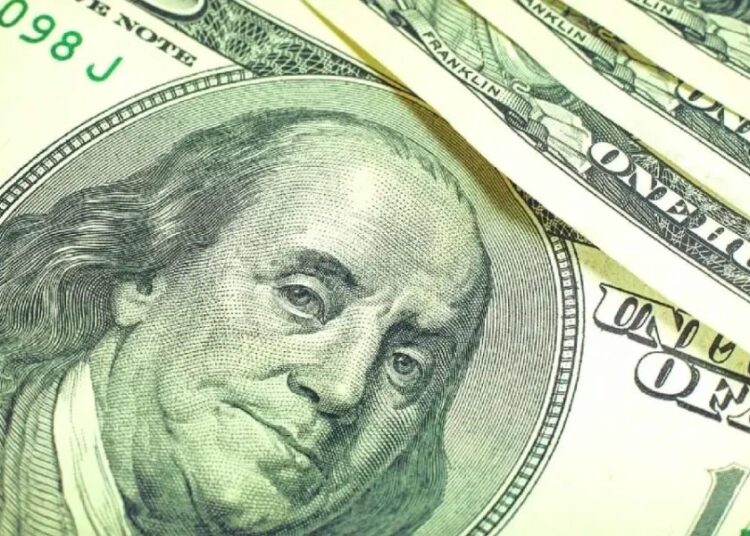 Billetes de peso mexicano y dólares estadounidenses sobre una mesa, reflejando la presión cambiaria del día