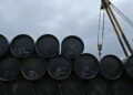 Buque petrolero navegando por el estrecho de Ormuz con plataformas de extracción de crudo al fondo