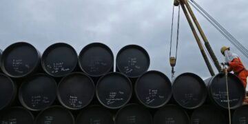 Buque petrolero navegando por el estrecho de Ormuz con plataformas de extracción de crudo al fondo