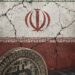 Pantalla con gráficos de criptomonedas y símbolo de candado de seguridad representando sanciones financieras internacionales contra plataformas iraníes