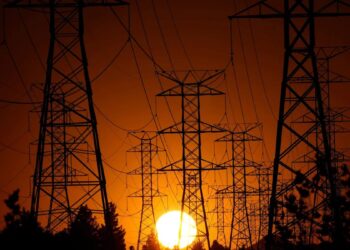 Torres de alta tensión eléctricas en Europa durante una ola de calor con cielo despejado