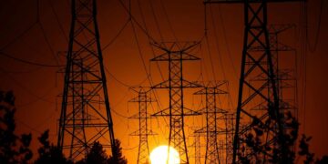 Torres de alta tensión eléctricas en Europa durante una ola de calor con cielo despejado