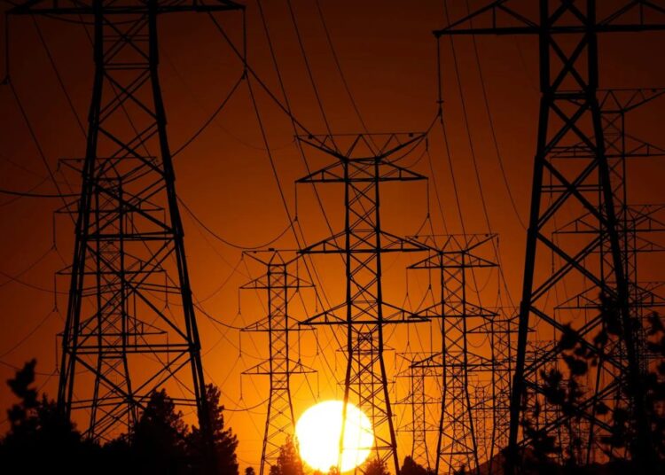 Torres de alta tensión eléctricas en Europa durante una ola de calor con cielo despejado