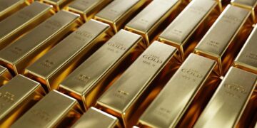 Barras de oro apiladas reflejando la caída del precio del metal desde máximos de 10 semanas