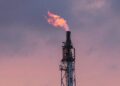 Plataforma petrolera con llamas en el mar durante tensiones geopolíticas en Medio Oriente