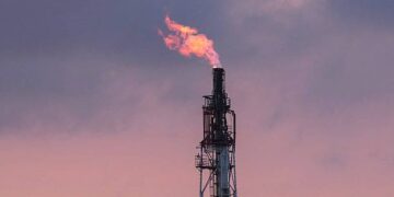 Plataforma petrolera con llamas en el mar durante tensiones geopolíticas en Medio Oriente