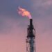 Plataforma petrolera con llamas en el mar durante tensiones geopolíticas en Medio Oriente