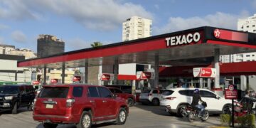 Surtidor de gasolina en una estación de combustible de República Dominicana con precios visibles en el tablero