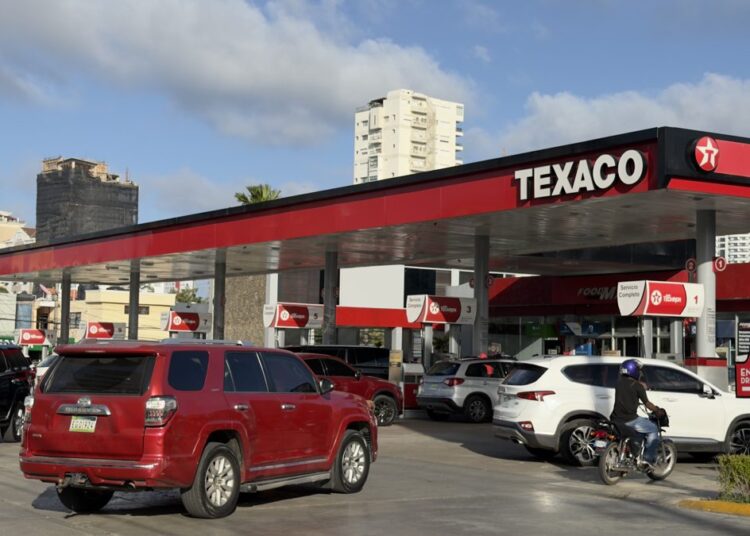 Surtidor de gasolina en una estación de combustible de República Dominicana con precios visibles en el tablero