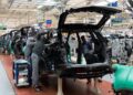 Línea de ensamblaje de vehículos en una planta automotriz de México con trabajadores y brazos robóticos