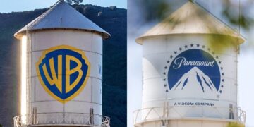 Logotipos de Warner Bros Discovery y Paramount Skydance en pantallas durante anuncio de fusión corporativa