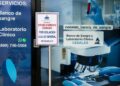 Inspectores del Ministerio de Salud Pública colocan aviso de clausura en banco de sangre CEDALAB en Villa Duarte, Santo Domingo Este