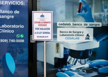 Inspectores del Ministerio de Salud Pública colocan aviso de clausura en banco de sangre CEDALAB en Villa Duarte, Santo Domingo Este
