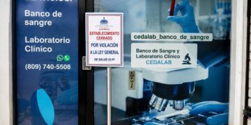 Inspectores del Ministerio de Salud Pública colocan aviso de clausura en banco de sangre CEDALAB en Villa Duarte, Santo Domingo Este