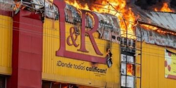 Brigadas de bomberos combaten un incendio en una sucursal de L&R Comercial en la avenida Las Américas