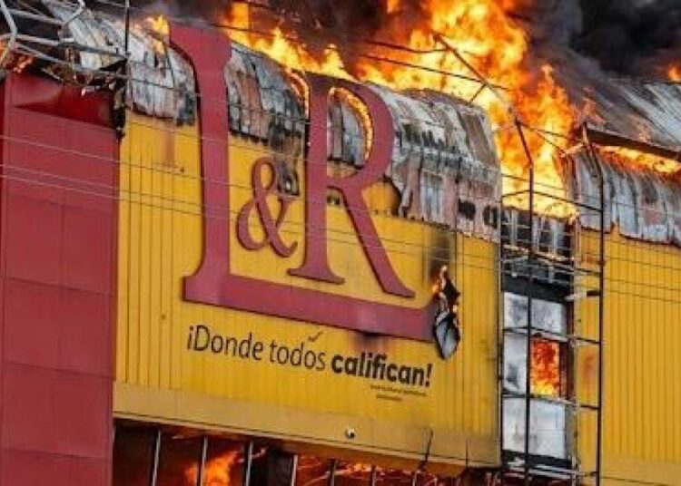 Brigadas de bomberos combaten un incendio en una sucursal de L&R Comercial en la avenida Las Américas