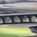Cauce seco de un río europeo en verano con barcazas varadas y tierra agrietada visible en la orilla