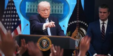 Donald Trump en la Casa Blanca mientras analistas observan la subida del precio del petróleo Brent en pantallas de trading