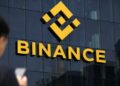 Pantalla con gráficos de criptomonedas y logo de Binance en dispositivo móvil