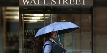 Pantalla electrónica en la Bolsa de Nueva York mostrando caídas del Dow Jones, S&P 500 y Nasdaq al cierre del viernes