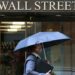 Pantalla electrónica en la Bolsa de Nueva York mostrando caídas del Dow Jones, S&P 500 y Nasdaq al cierre del viernes