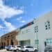 Fachada de un hospital público dominicano con estantes de medicamentos en el área de farmacia