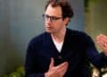 Dario Amodei, CEO de Anthropic, frente a pantallas con código de inteligencia artificial durante presentación corporativa