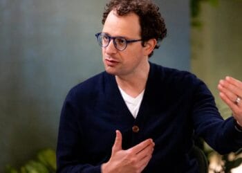 Dario Amodei, CEO de Anthropic, frente a pantallas con código de inteligencia artificial durante presentación corporativa