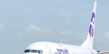 Avión de Arajet en pista con logo púrpura visible durante celebración de cuarto aniversario