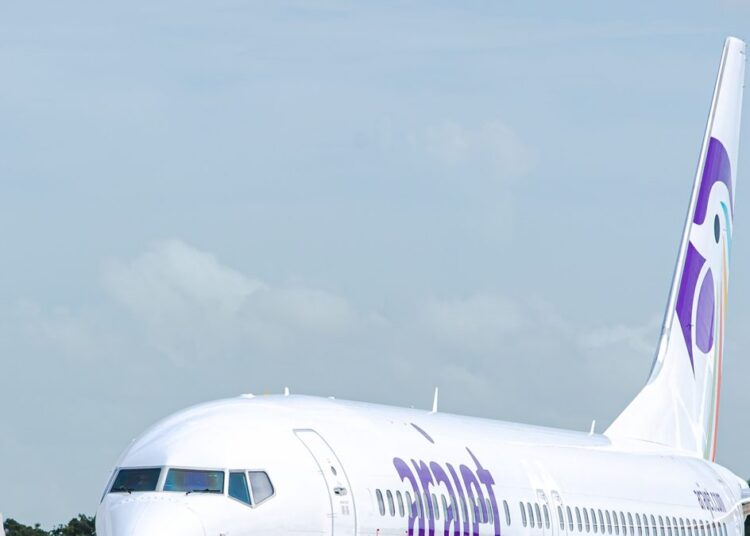 Avión de Arajet en pista con logo púrpura visible durante celebración de cuarto aniversario