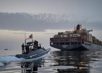 Buque mercante navegando cerca del estrecho de Ormuz con tensión militar en la zona