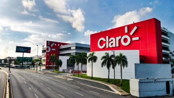 Logo de Claro Dominicana en una tienda mientras técnicos revisan sistemas de seguridad informática