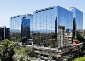 Comerciante mexicano usando terminal de pago digital en una tienda de abarrotes