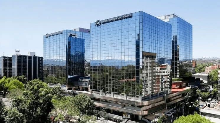 Comerciante mexicano usando terminal de pago digital en una tienda de abarrotes