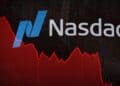 Pantalla del Nasdaq en Times Square mostrando caída bursátil con operadores en Wall Street al fondo