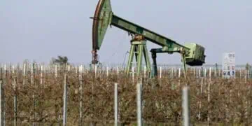 Plataforma de extracción de petróleo con barriles y precio del WTI en pantalla