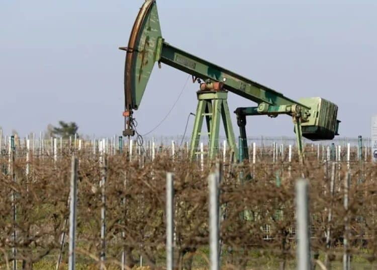 Plataforma de extracción de petróleo con barriles y precio del WTI en pantalla
