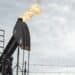Barriles de petróleo apilados en una refinería con indicadores de precios al alza en pantallas de mercado