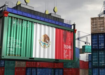 Trabajadores en planta de manufactura electrónica en México con equipos de ensamblaje de servidores y computadoras