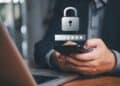 Persona revisando su teléfono celular con alerta de fraude bancario en pantalla