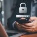Persona revisando su teléfono celular con alerta de fraude bancario en pantalla