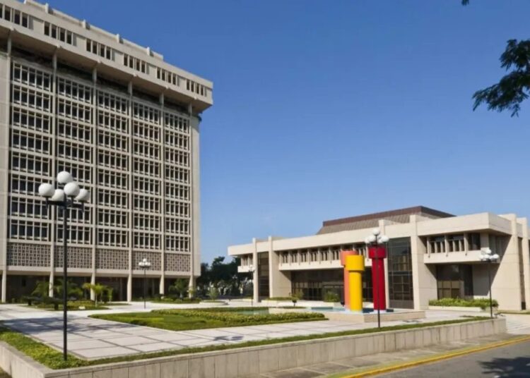 Billetes de dólares estadounidenses junto a pesos dominicanos sobre una mesa, representando los flujos de inversión extranjera directa en República Dominicana