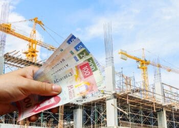 Parque industrial en México con plantas manufactureras en operación y grúas de construcción al fondo